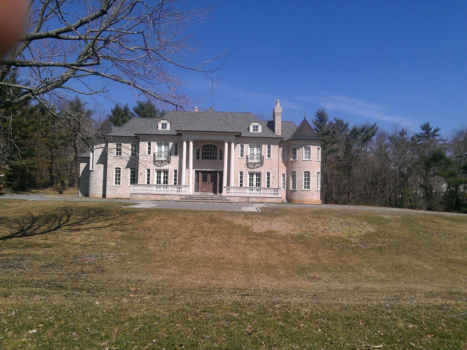 Roof installation on a large brick estate home with turret in Suffolk County, Long Island